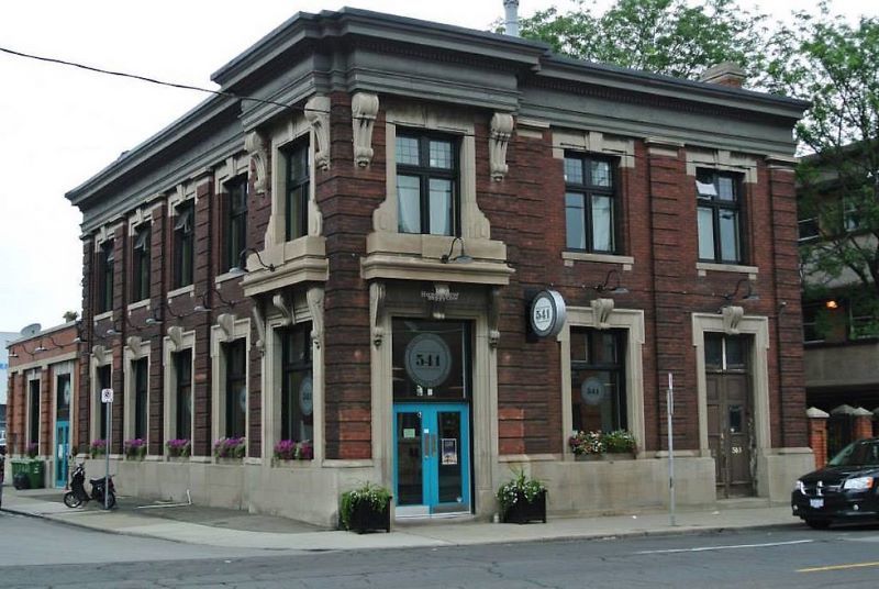 an old corner building with red bricks and a blue door