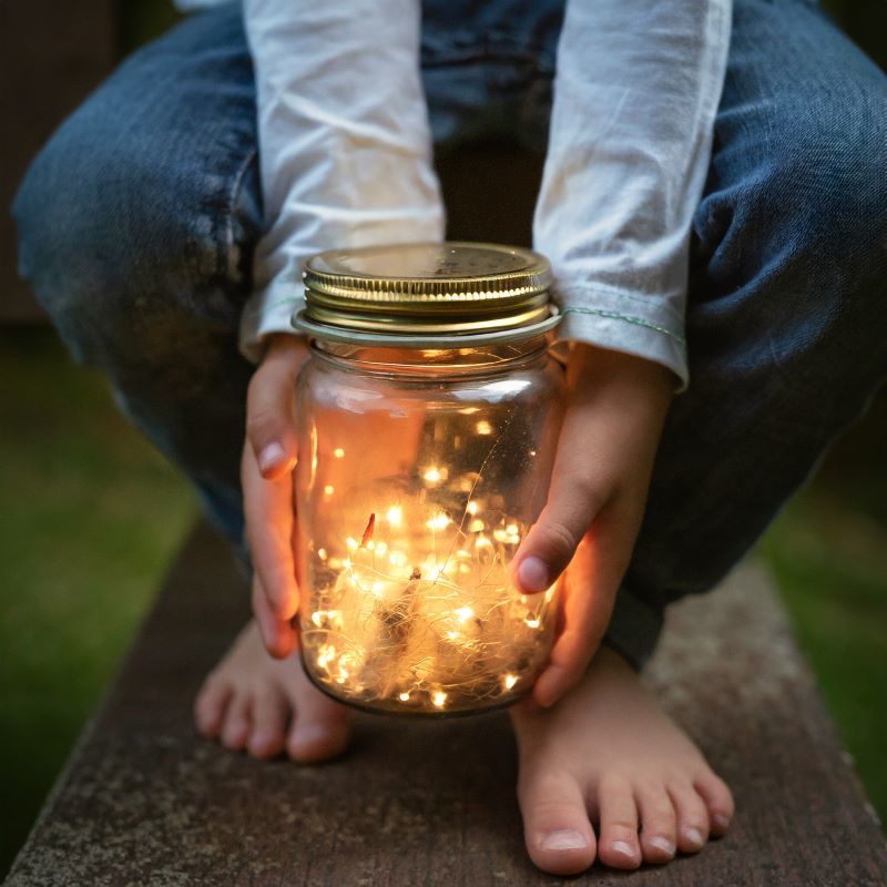 fireflies in jar held by child