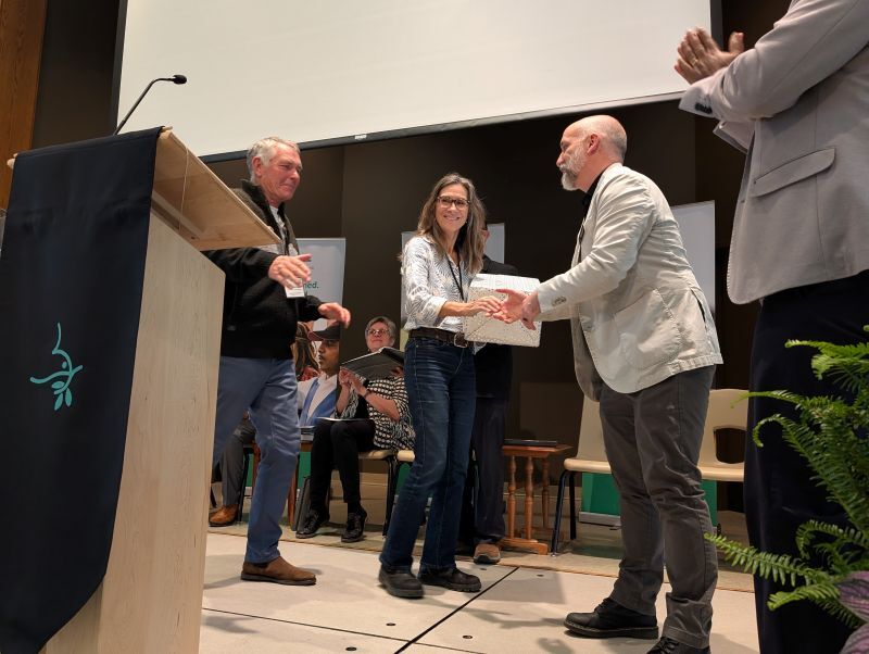 man handing a woman and man a gift