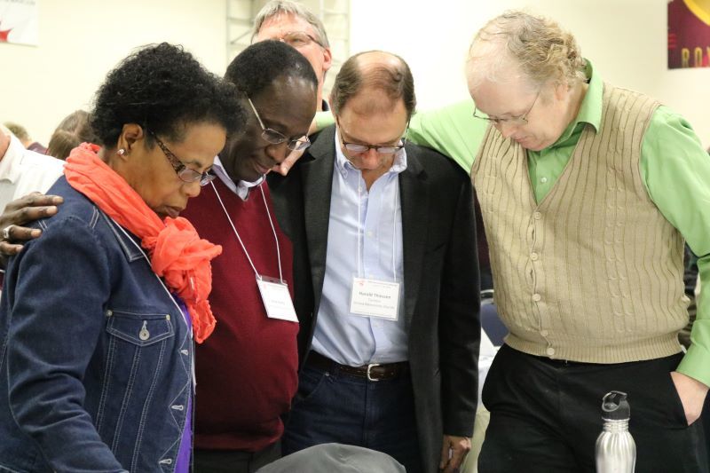 four people praying for each other