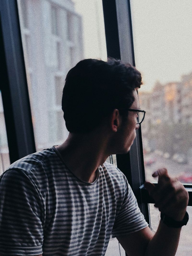 Man Looking Out Window