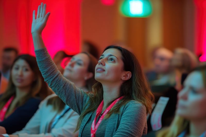 woman in crowd raising hand