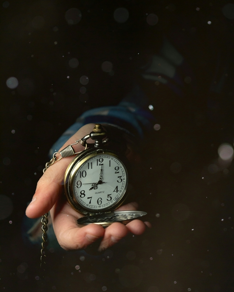hand holding stop watch in a darkened room