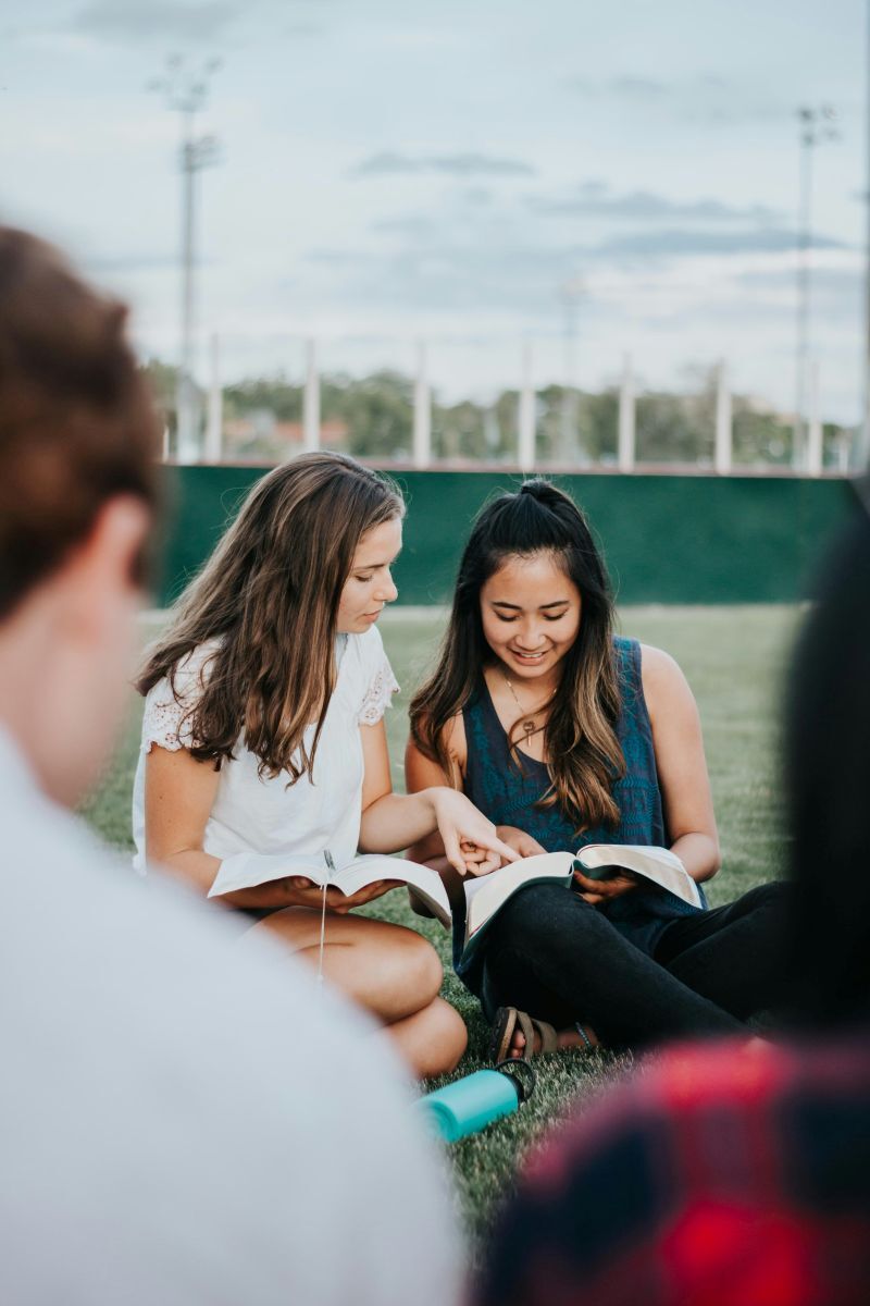 young adults studying the Bible outdoors