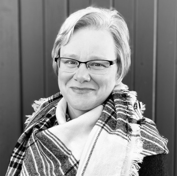 black and white photo of woman smiling wearing glasses wearing shawl