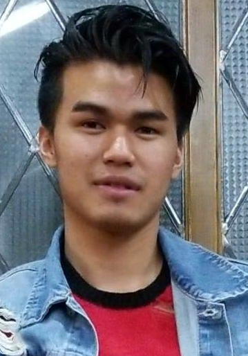 Asian man wearing a jean jacket and a red and black striped sweater