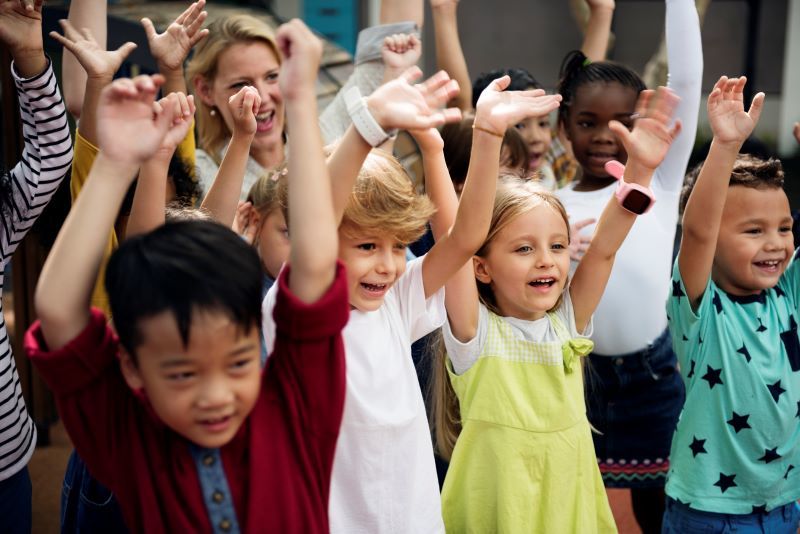 children smiling with arms raised