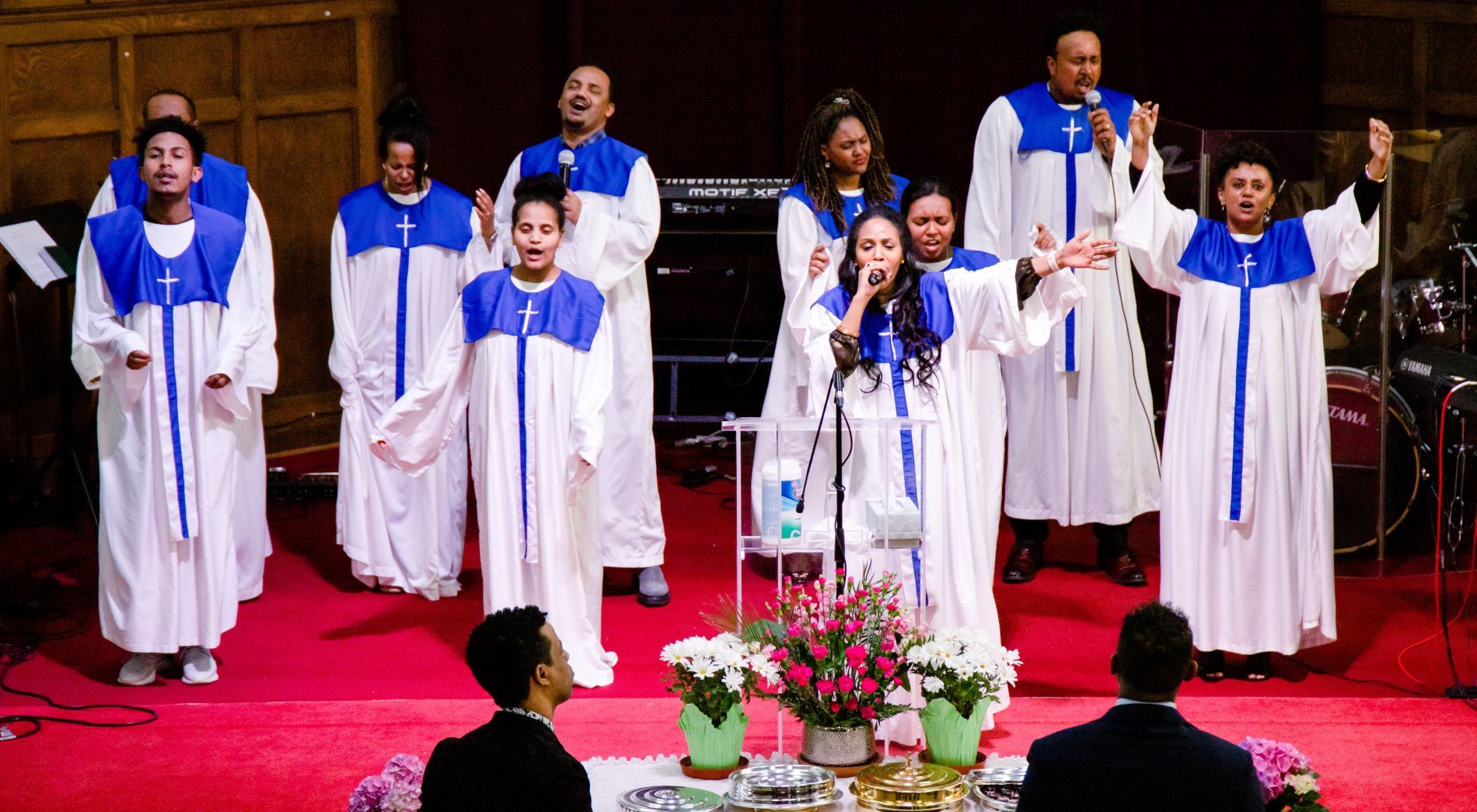 Choir wearing gowns worshipping on a stage