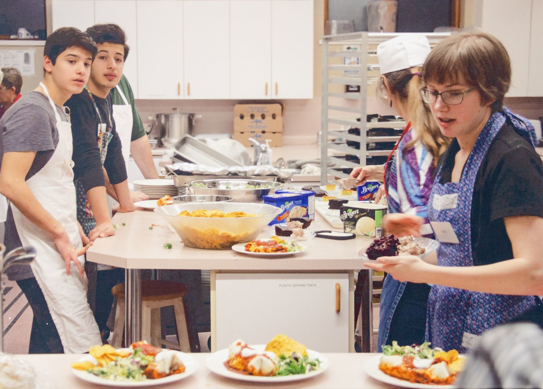 youth working at counter in a kitchen preparing meals