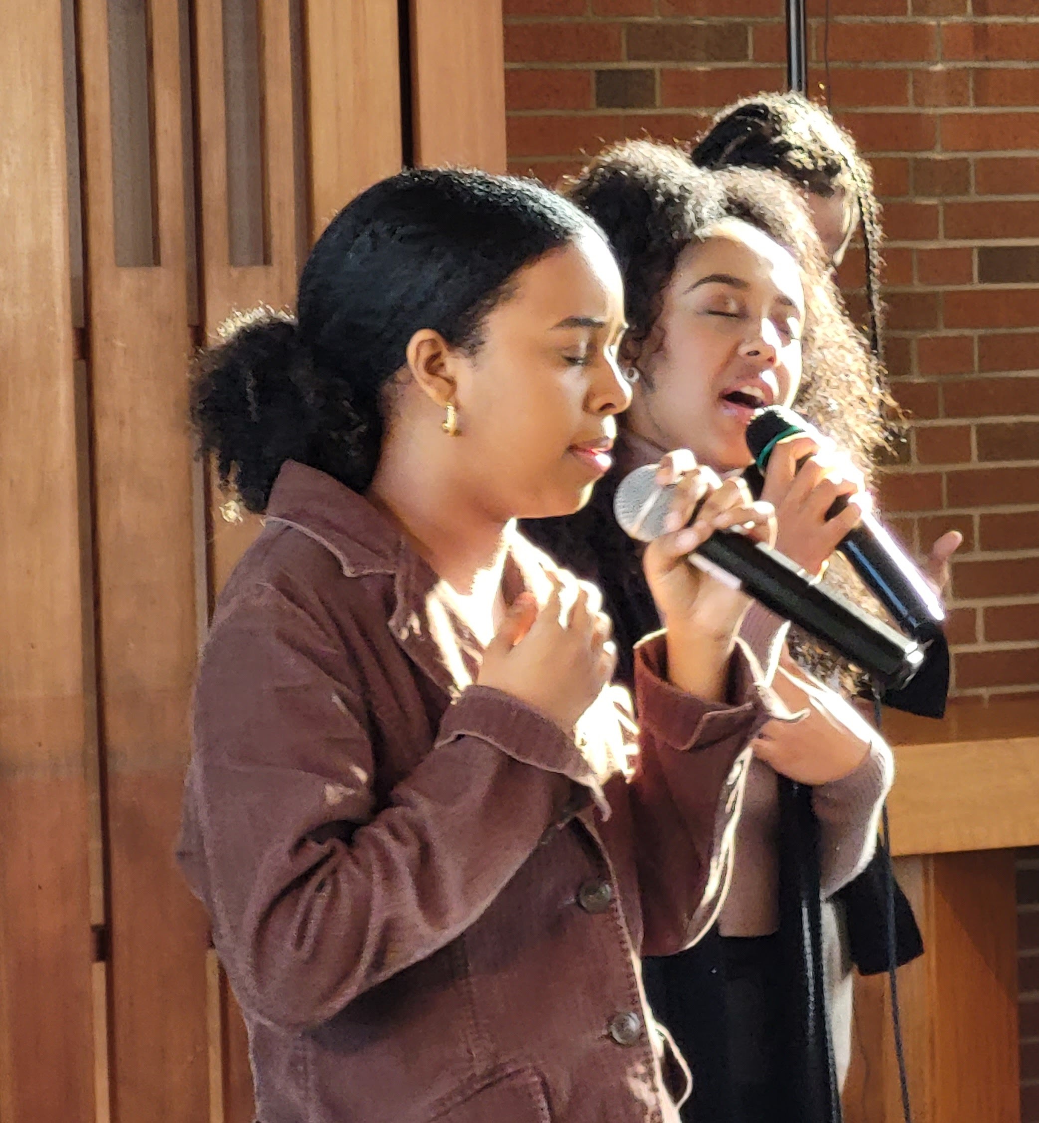 three young adult women leading worship