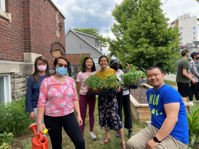 youth and adults posing after planting garden