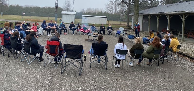 outside circle of students in lawnchairs