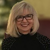 woman smiling at Christmas tree