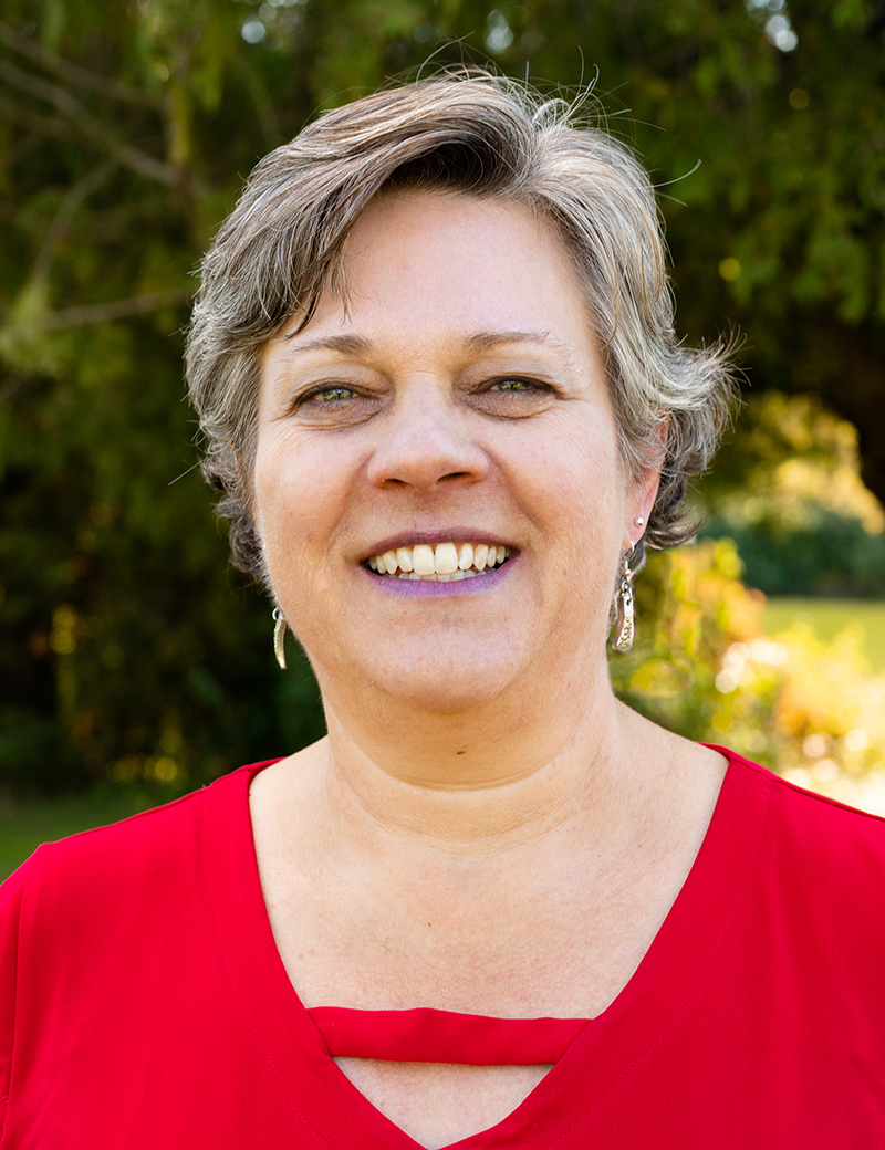 smiling woman in red shirt outside