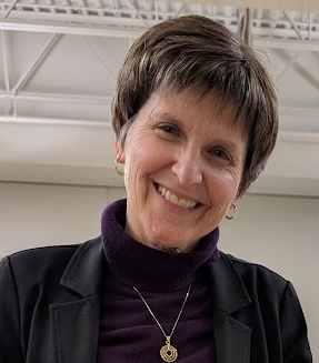 smiling woman indoors wearing purple